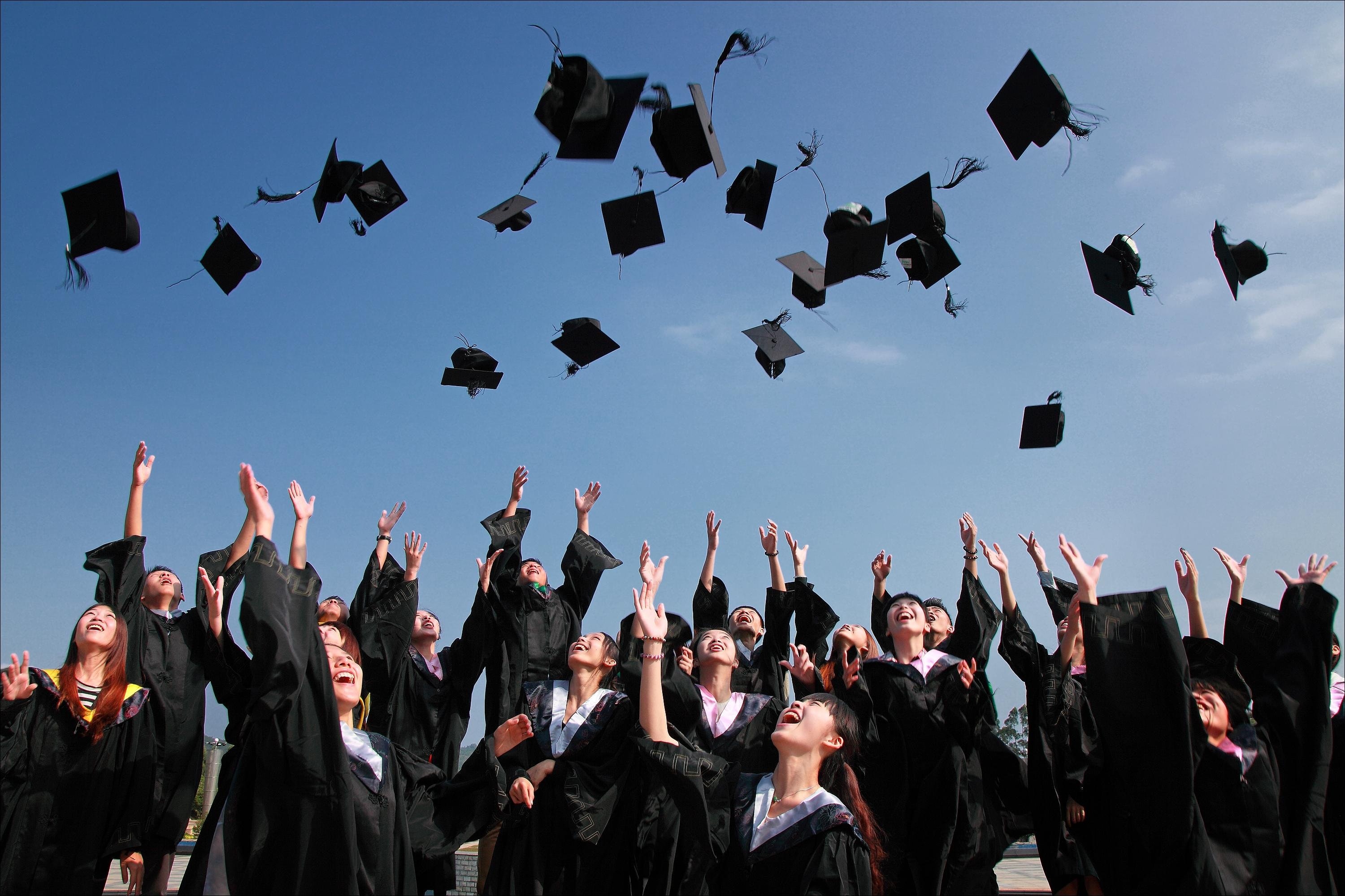 graduation hats being thrown in the air